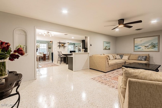 living room featuring visible vents, baseboards, ceiling fan, light speckled floor, and recessed lighting