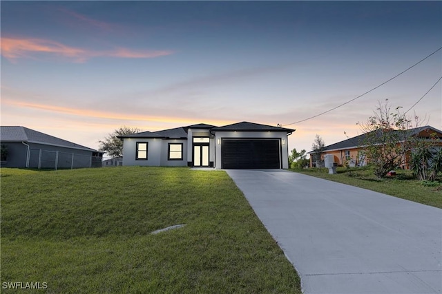 view of front of home featuring a yard, stucco siding, concrete driveway, fence, and a garage