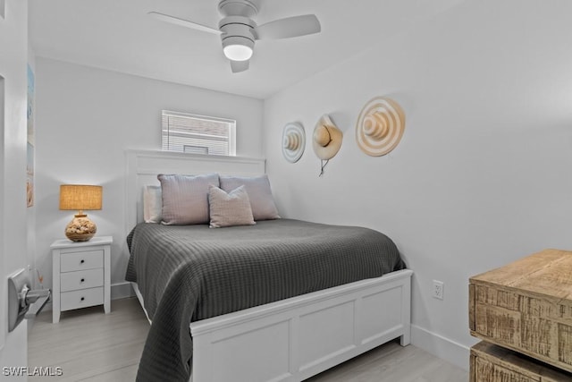 bedroom featuring ceiling fan, baseboards, and wood finished floors