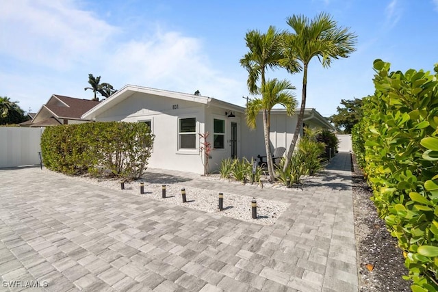 view of front of house with fence and stucco siding