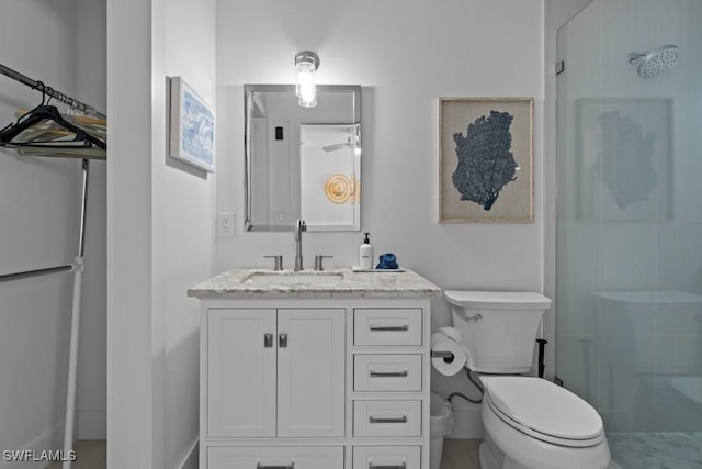 bathroom featuring toilet, a stall shower, and vanity