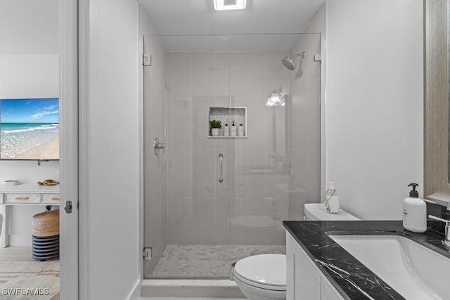 bathroom featuring a stall shower, vanity, and toilet