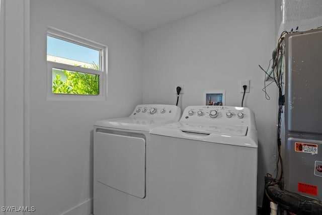 laundry area with laundry area, washer and clothes dryer, and heating unit