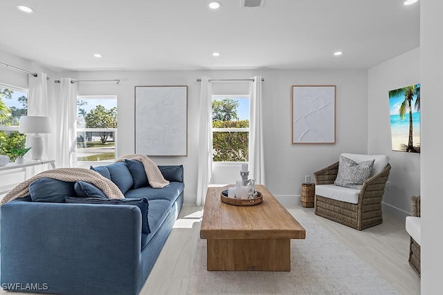 living area featuring baseboards, plenty of natural light, and recessed lighting