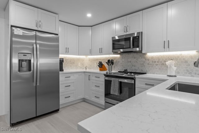 kitchen featuring white cabinets, light stone countertops, and stainless steel appliances