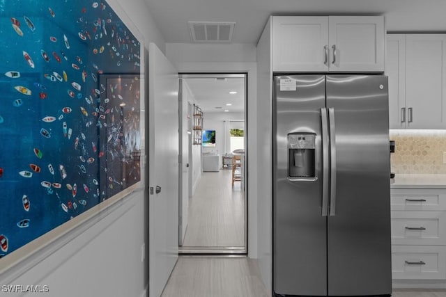 kitchen with visible vents, white cabinets, and stainless steel fridge with ice dispenser