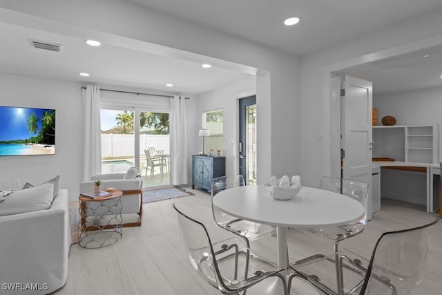 dining space with light wood-type flooring, visible vents, and recessed lighting