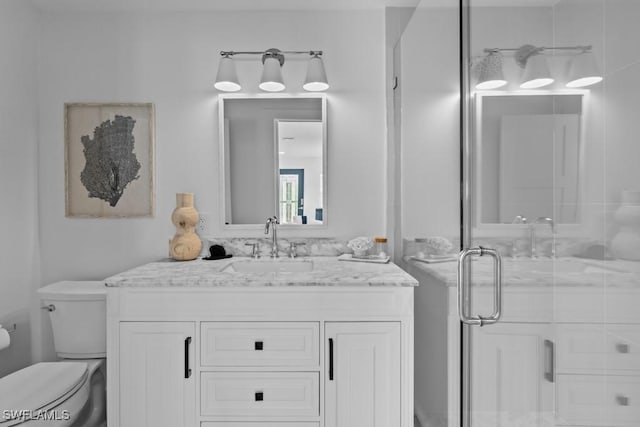 bathroom with a stall shower, vanity, and toilet