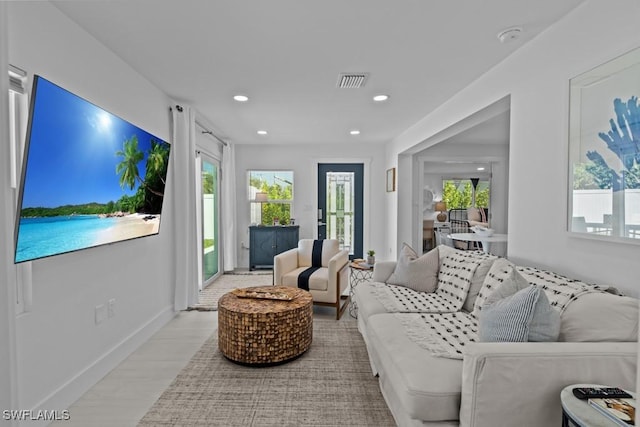 living area with baseboards, light wood finished floors, visible vents, and recessed lighting