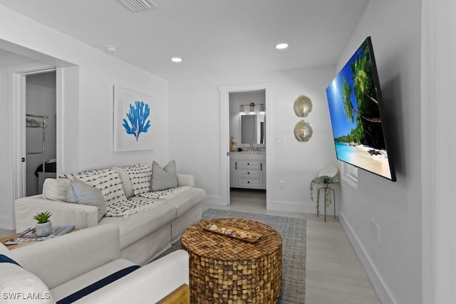 living room featuring recessed lighting, visible vents, light wood finished floors, and baseboards