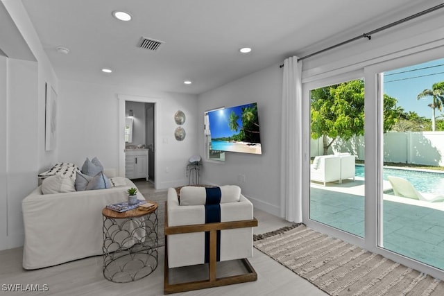 living room with recessed lighting, visible vents, and baseboards