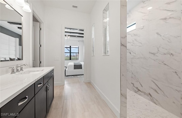 ensuite bathroom featuring a marble finish shower, baseboards, visible vents, ensuite bath, and vanity