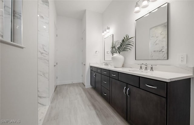 bathroom featuring double vanity, a sink, and baseboards