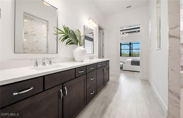 bathroom featuring connected bathroom, visible vents, a sink, and double vanity