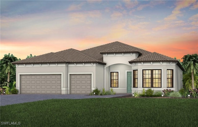 view of front facade with a tiled roof, an attached garage, decorative driveway, a yard, and stucco siding