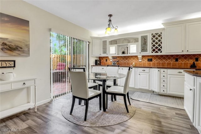 dining area featuring light wood-type flooring and baseboards