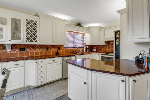 kitchen featuring stainless steel appliances, tasteful backsplash, glass insert cabinets, white cabinetry, and a sink