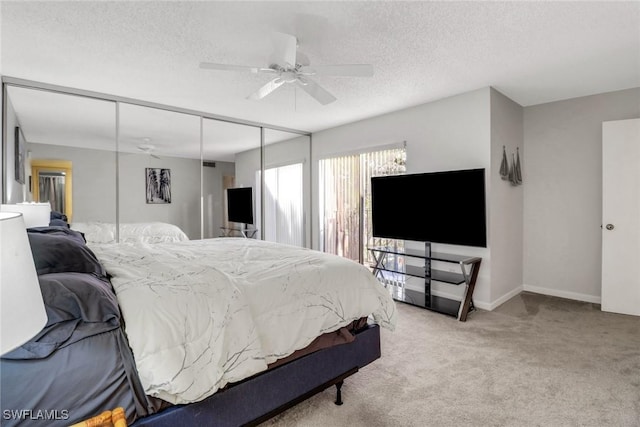 bedroom featuring a textured ceiling, carpet flooring, a ceiling fan, baseboards, and a closet