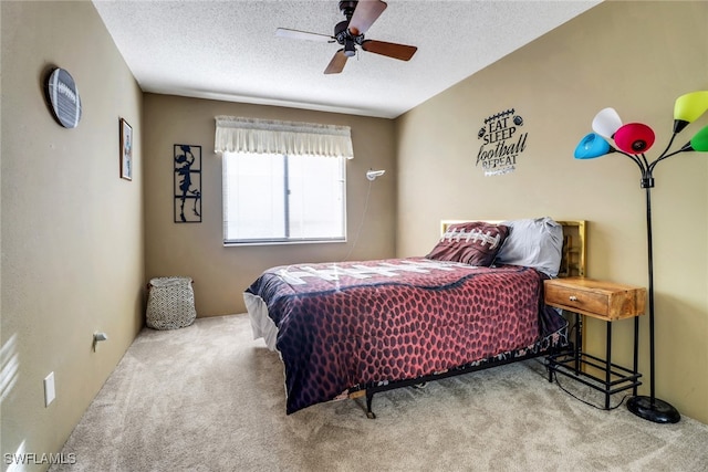 carpeted bedroom featuring a ceiling fan and a textured ceiling