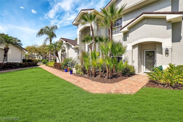 exterior space with a yard and stucco siding