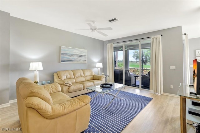 living room with light wood-style floors, visible vents, ceiling fan, and baseboards