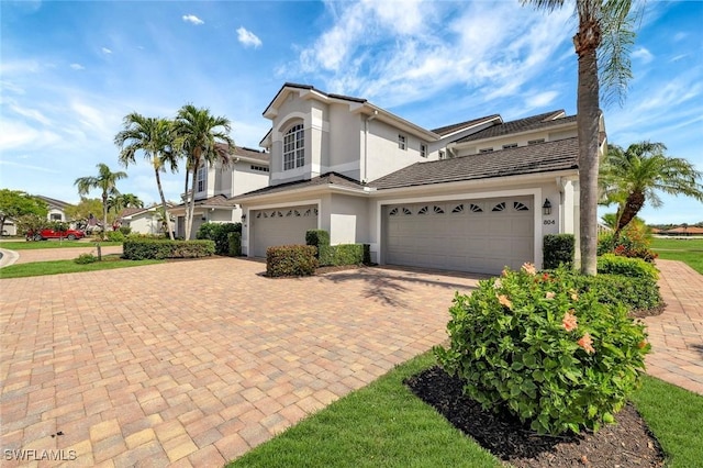 view of front of house with decorative driveway and stucco siding