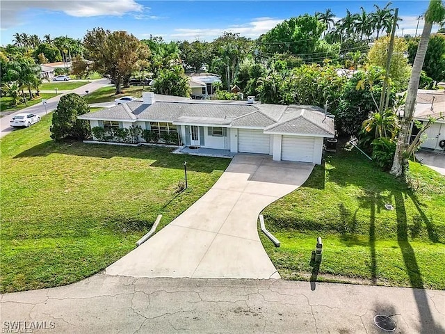 ranch-style house with a front lawn, concrete driveway, and an attached garage