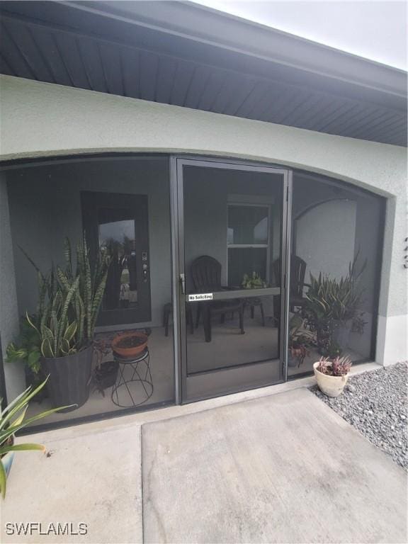 view of exterior entry featuring stucco siding