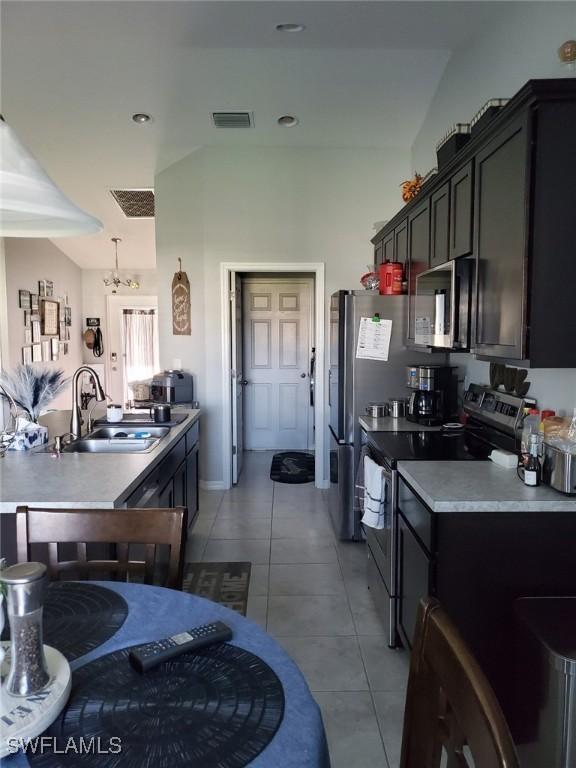 kitchen with light tile patterned floors, a sink, visible vents, light countertops, and appliances with stainless steel finishes