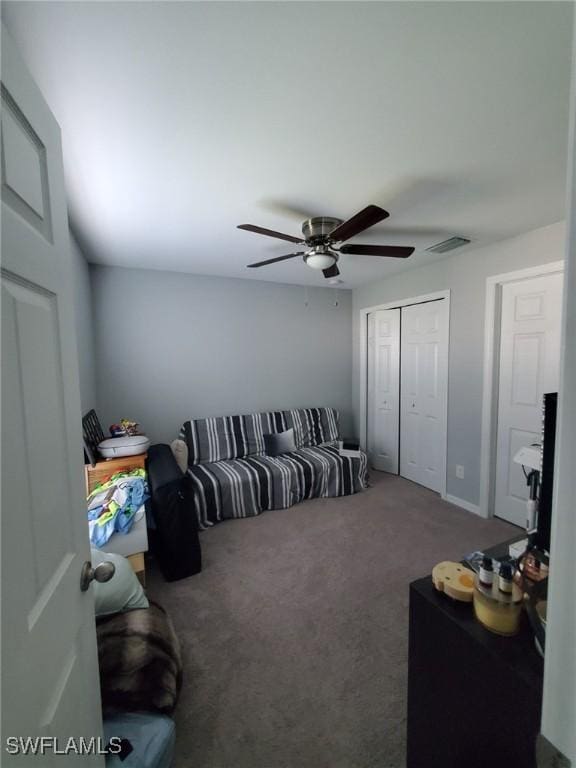 carpeted living room featuring visible vents and a ceiling fan