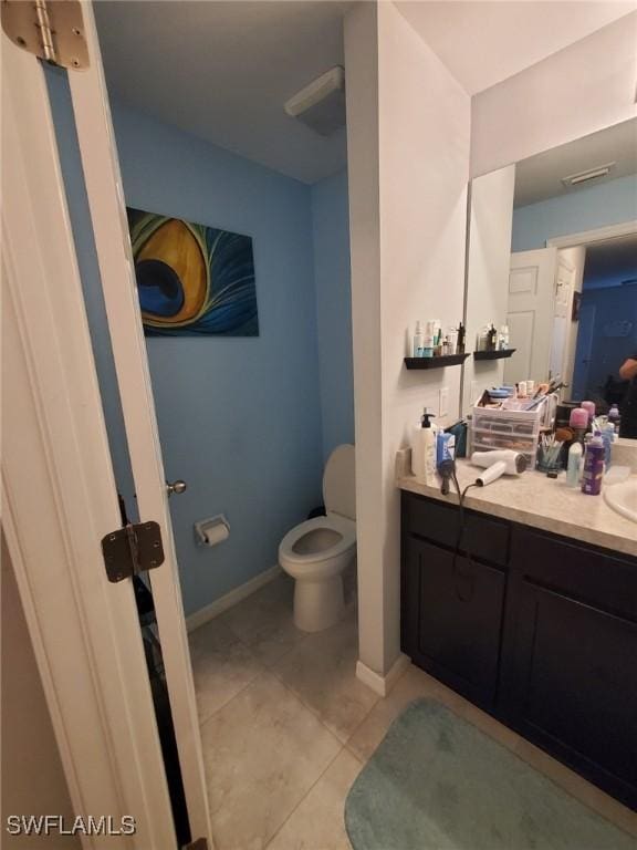 bathroom with baseboards, vanity, toilet, and tile patterned floors