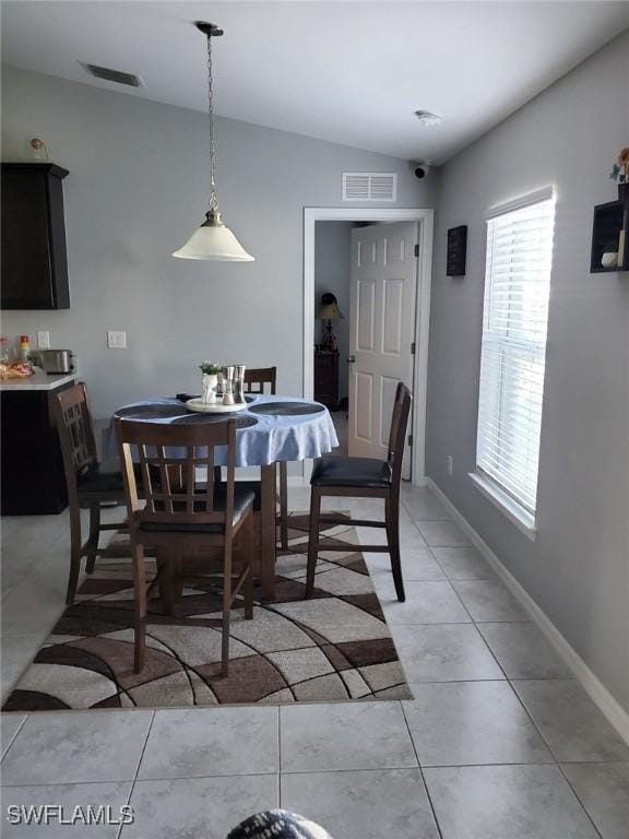 dining space with lofted ceiling, visible vents, and baseboards