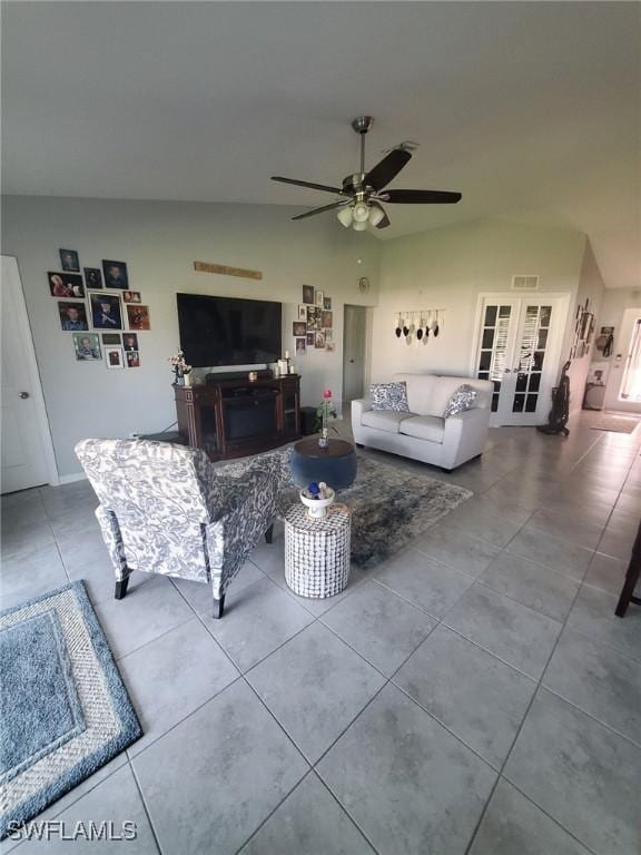 living room featuring lofted ceiling, tile patterned flooring, ceiling fan, and visible vents