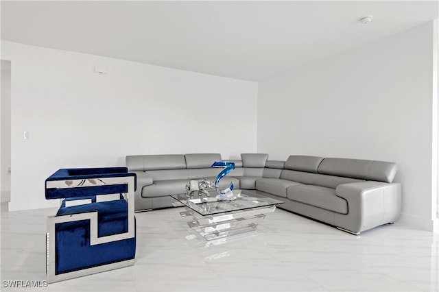 living area featuring marble finish floor and baseboards