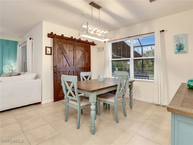 dining space featuring light tile patterned floors, a barn door, and baseboards