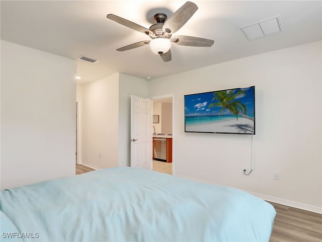 bedroom featuring light wood-style floors, visible vents, and baseboards