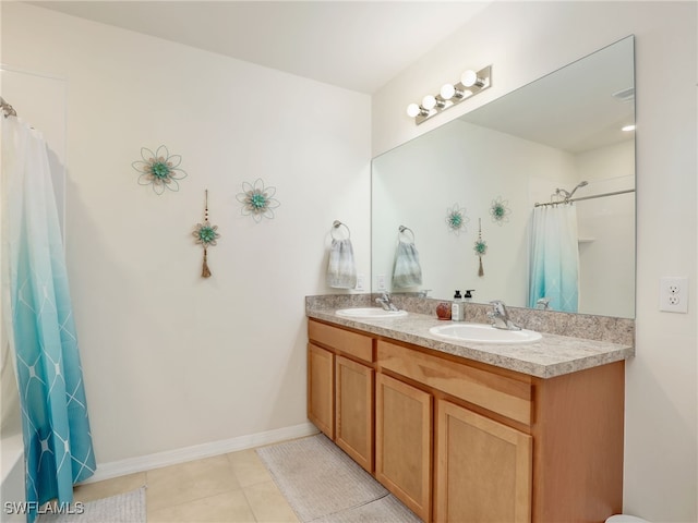 bathroom featuring tile patterned floors, a sink, baseboards, and double vanity