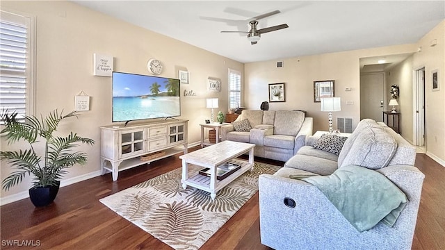 living area with a ceiling fan, wood finished floors, visible vents, and baseboards