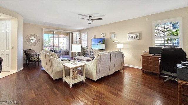 living room featuring dark wood-style flooring, ceiling fan, and baseboards