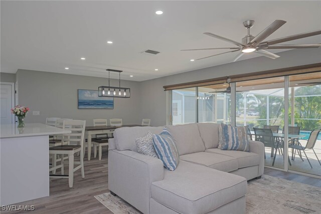 living area featuring ceiling fan, wood finished floors, visible vents, and recessed lighting