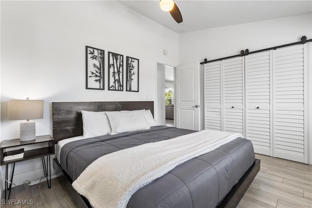 bedroom with light wood-type flooring, lofted ceiling, ceiling fan, and baseboards