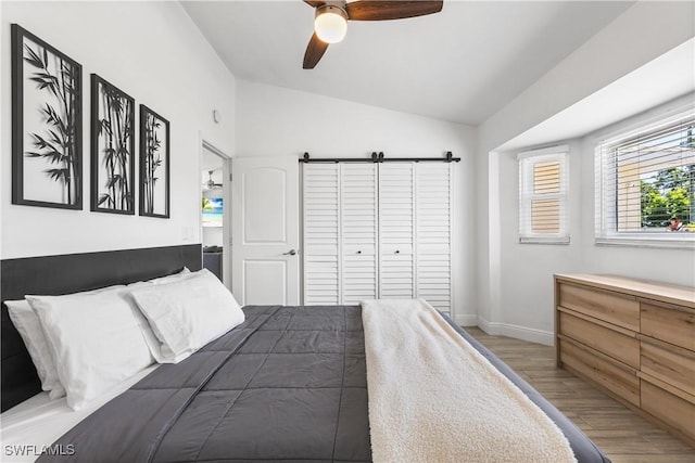 bedroom with lofted ceiling, light wood-style flooring, baseboards, and ceiling fan