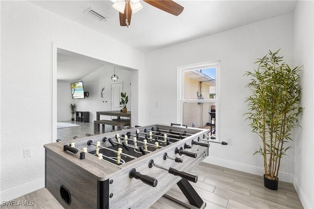 game room with a wealth of natural light, visible vents, ceiling fan, and baseboards