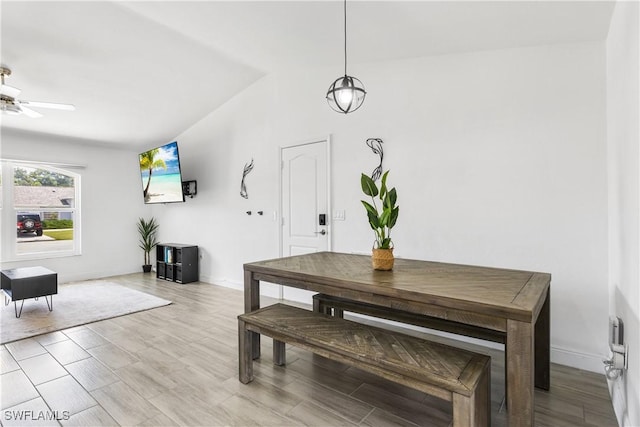 dining room with lofted ceiling, light wood-style floors, a ceiling fan, and baseboards