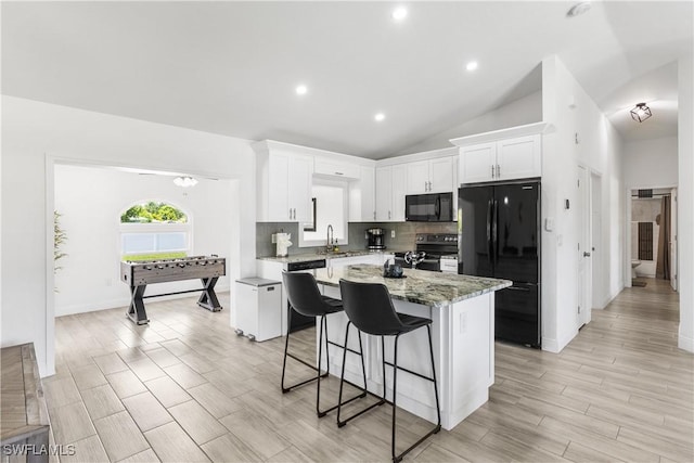 kitchen with a kitchen island, a sink, white cabinets, decorative backsplash, and black appliances