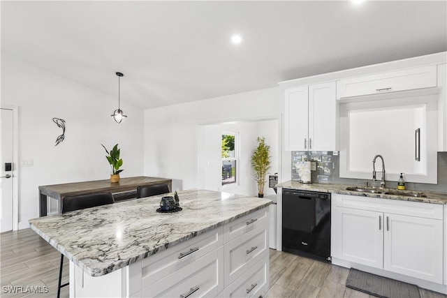 kitchen featuring dishwasher, light stone counters, wood finish floors, and a sink