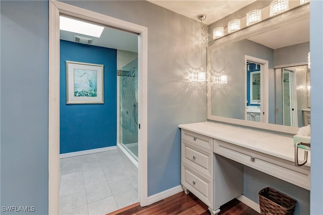 full bath with a shower stall, visible vents, baseboards, and vanity