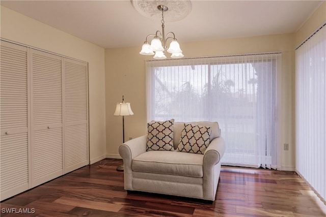 living area featuring a notable chandelier, baseboards, and wood finished floors