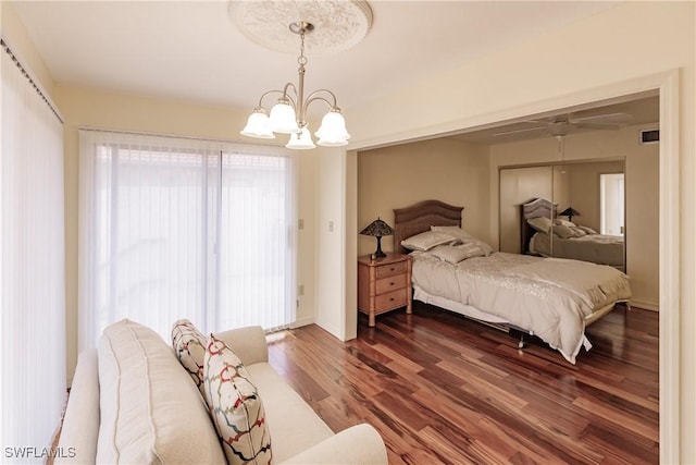 bedroom featuring a notable chandelier, dark wood finished floors, a closet, visible vents, and baseboards