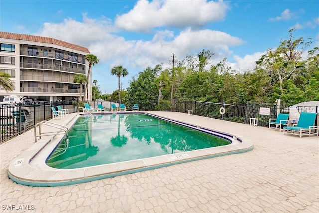 community pool with fence and a patio